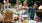 a group of people sitting around a table with food